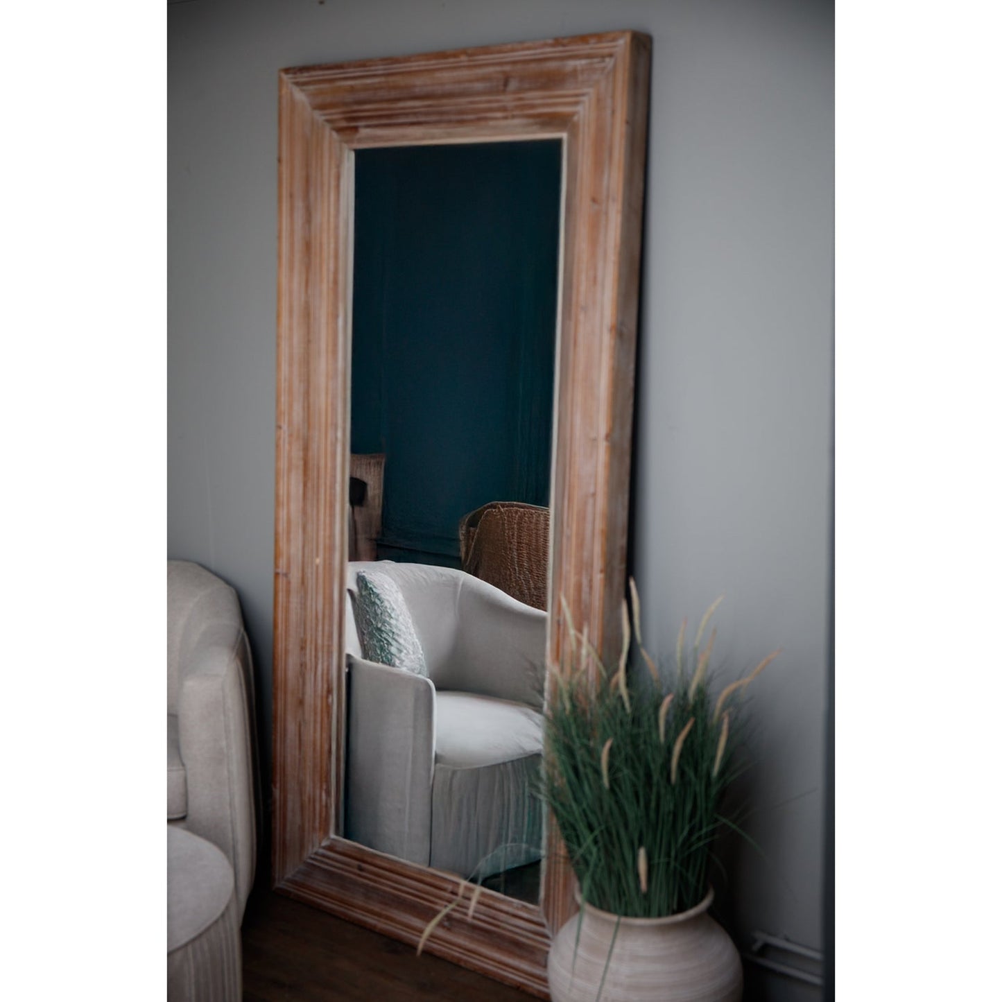 washed wood large mirror leaning up against wall