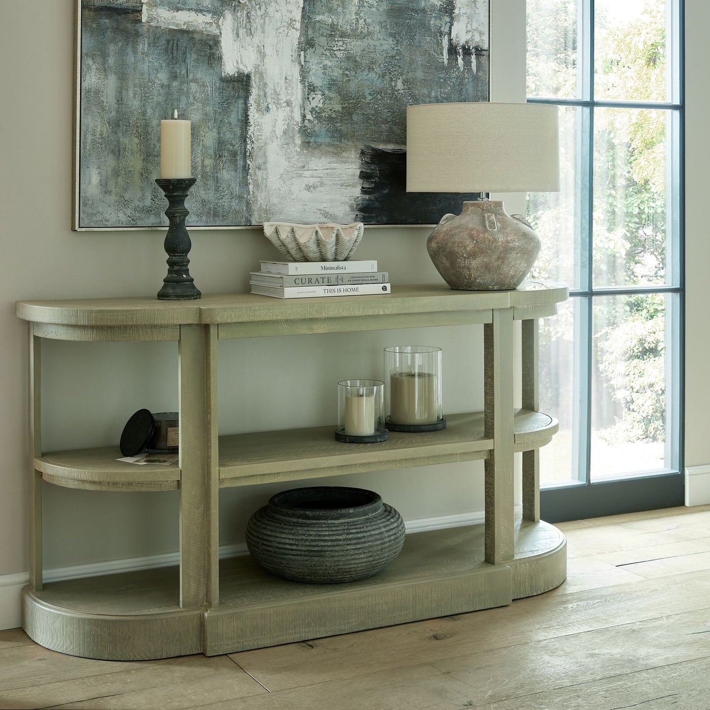 console table against wall with various decor pieces and lamp on