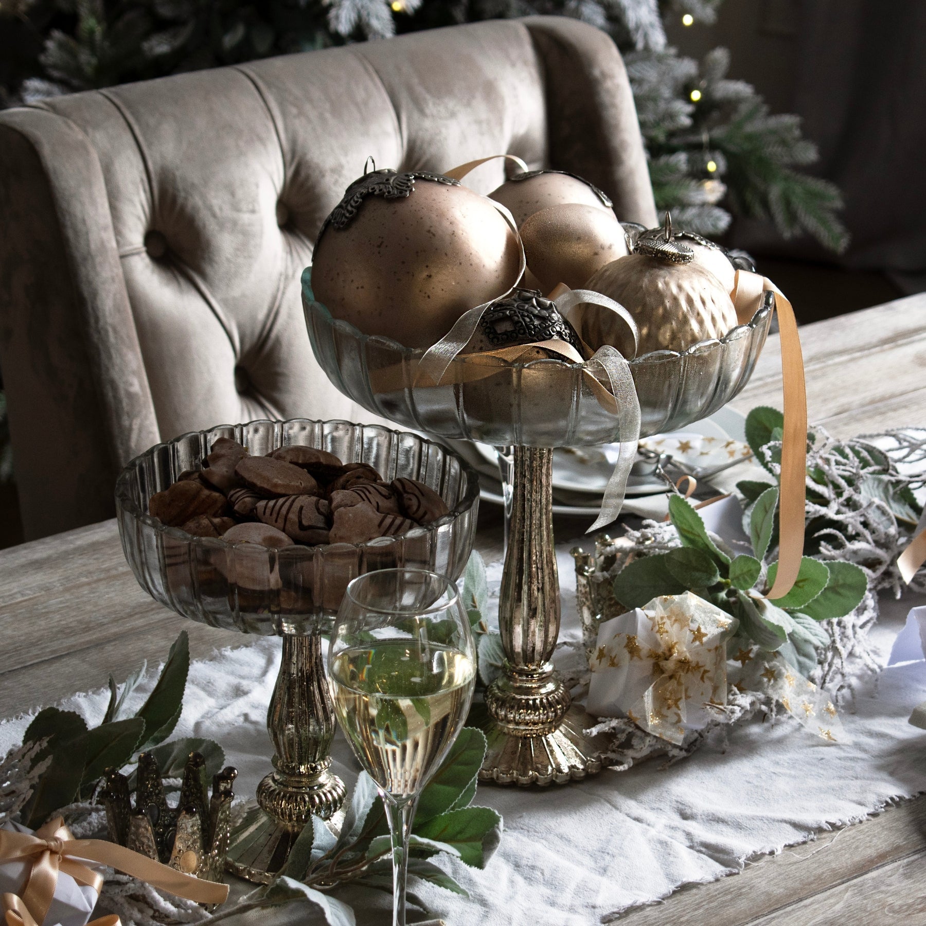 small and medium fluted glass display bowls as centrepiece for dining table. Small bowl filled with decorative shells and medium bowl filled with varying size gold baubles