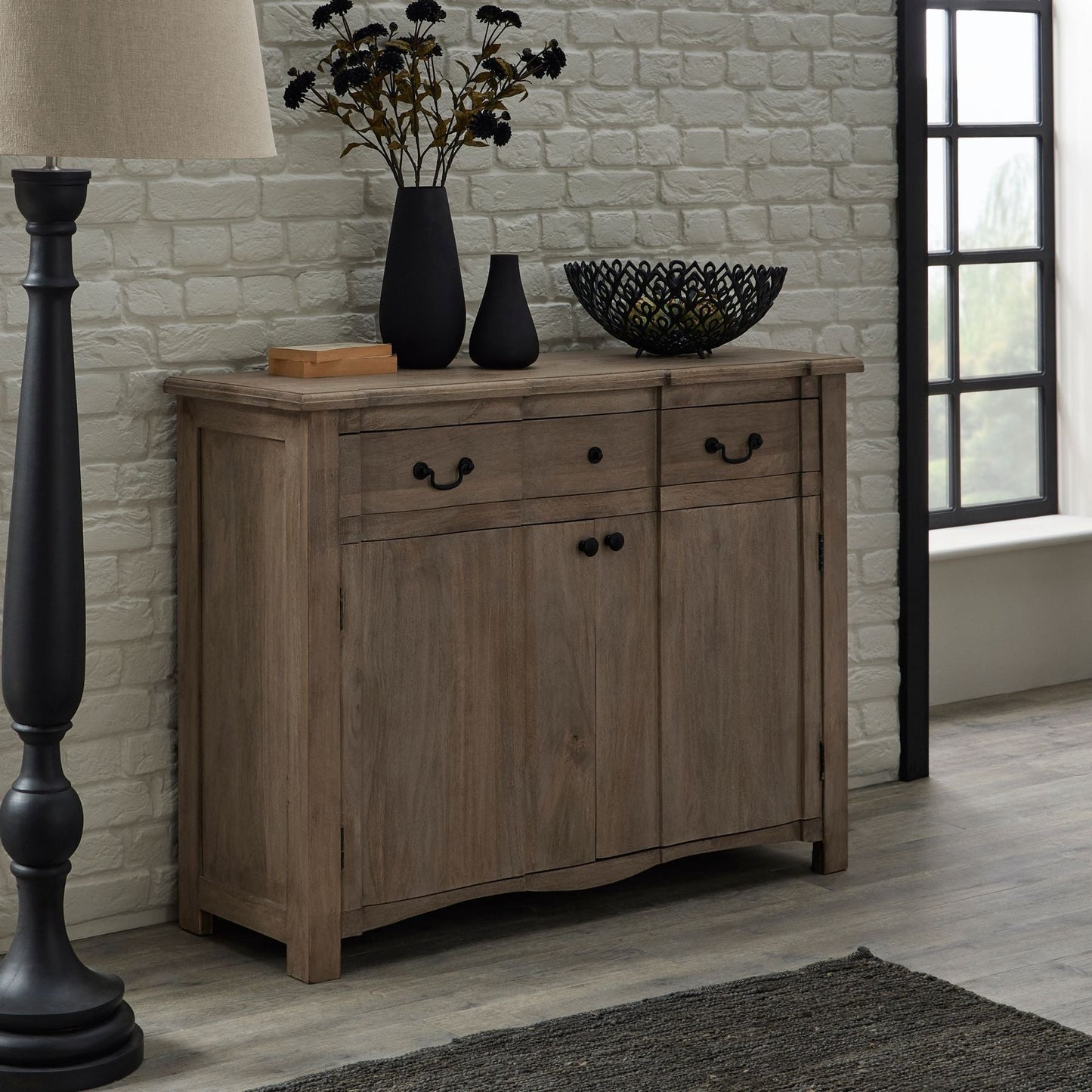 lifestyle image of sideboard with accessories on top and a floor lamp beside