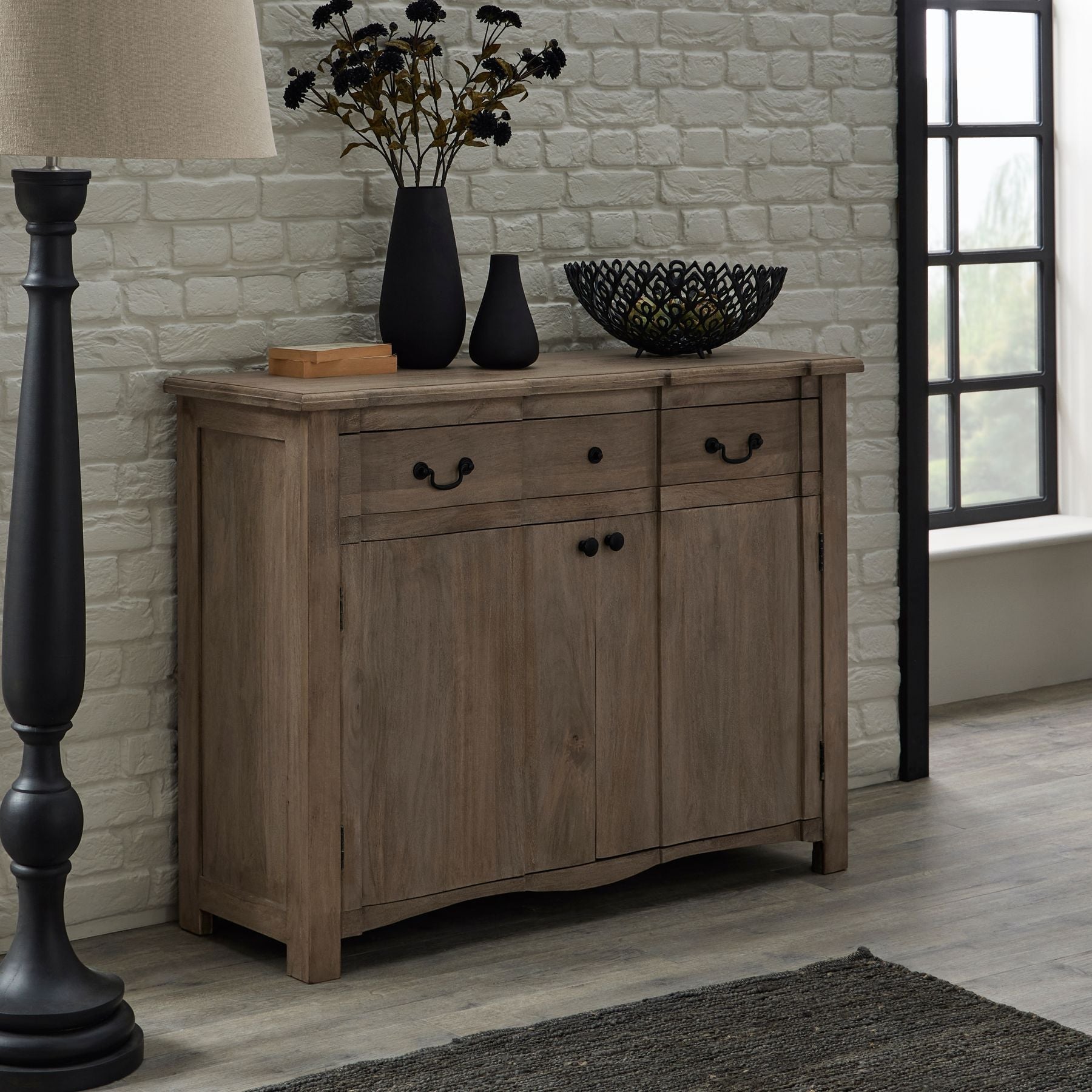 lifestyle image of sideboard with accessories on top and a floor lamp beside