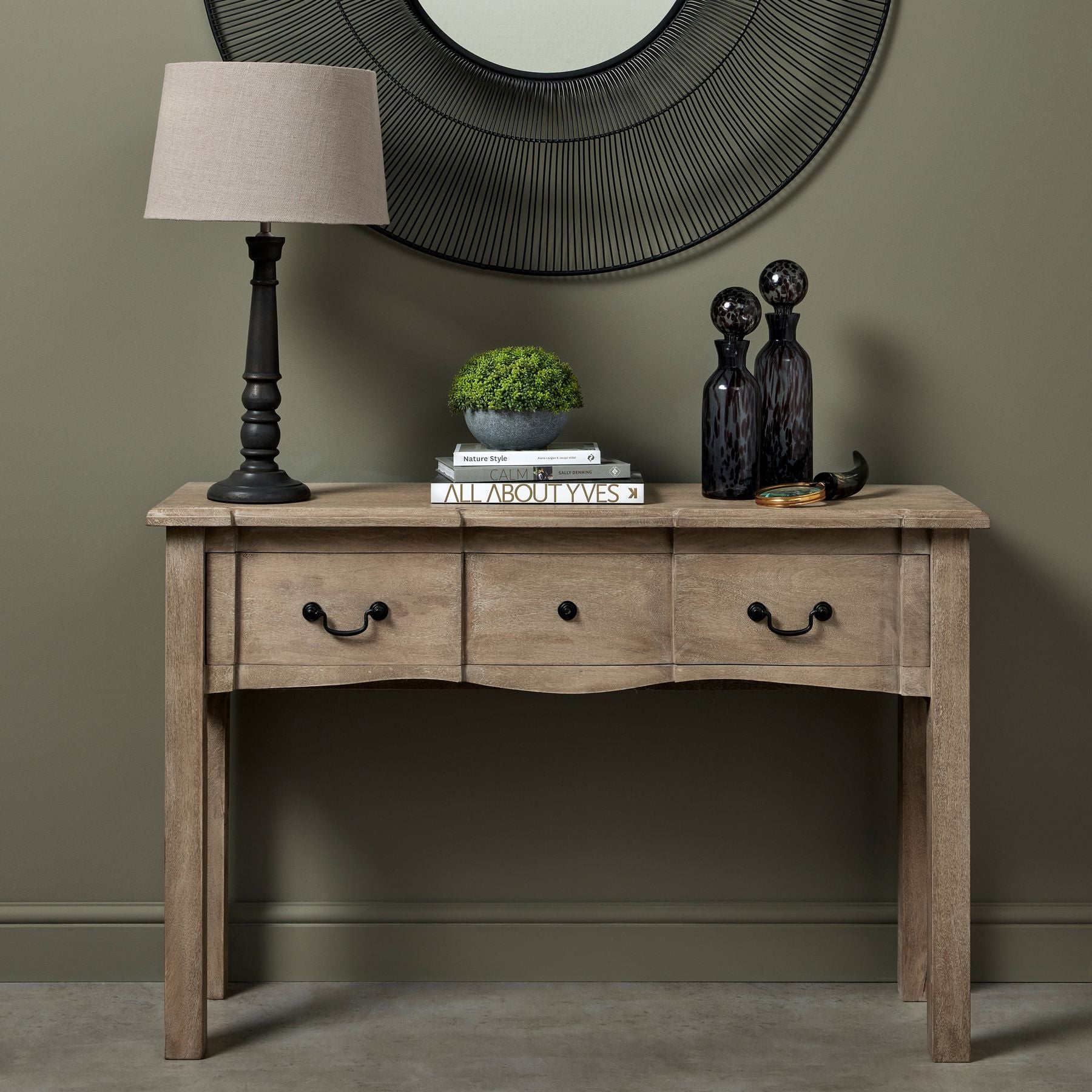wood console table with decor pieces on top, a mirror hung behind