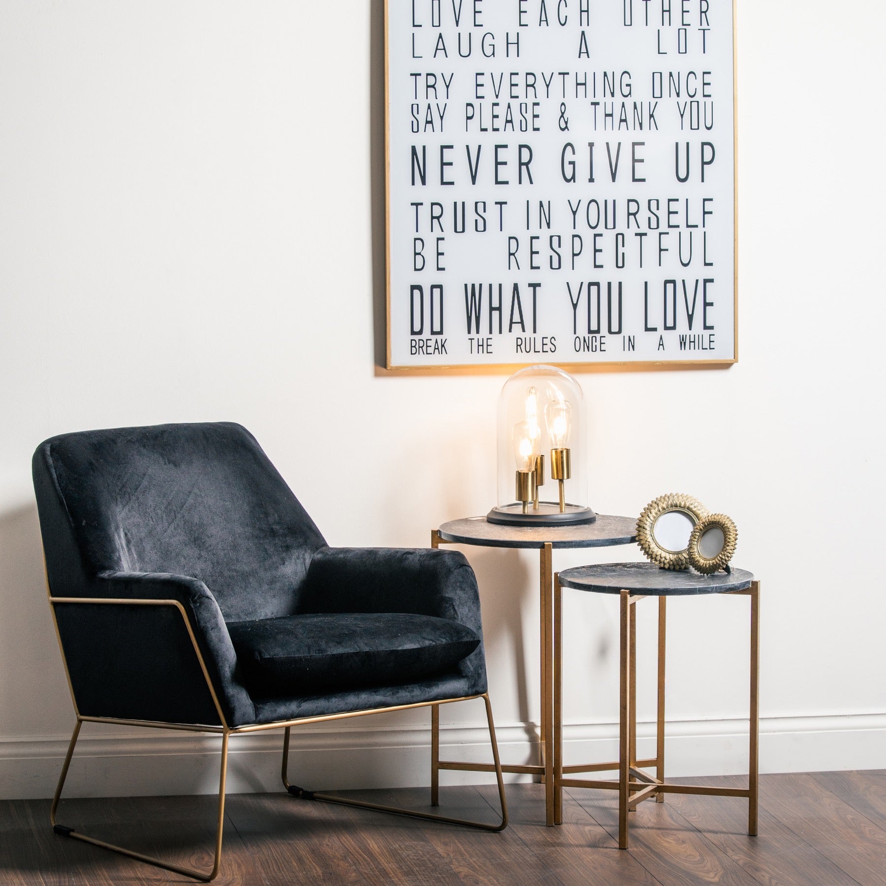 tables set up as a nest, photo frame on table and lamp on the larger table. Black velvet chair gold frame is next to tables